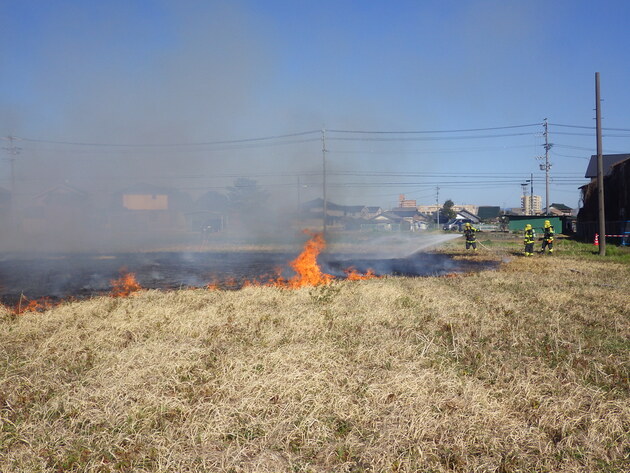 枯草火災を消防隊が消火している画像